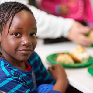 Portrait of a little girl sitting at a dining table with food provided by volunteershttp://195.154.178.81/DATA/i_collage/pi/shoots/805749.jpg